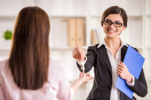 Femme agent immobilier remettant la clé à un nouveau propriétaire d'un appartement.